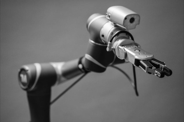 A compact collaborative robot arm with a vision camera and gripper, ready for pick-and-place work